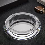 Clear round crystal glass ashtray on dark surface