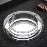 Silver round crystal glass ashtray close-up on dark surface