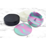 Black, glow white and marbled silicone ashtrays with lids on white surface