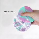 Hand cleaning marbled silicone ashtray under running water