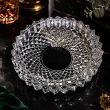 Crystal glass clear ashtray on a dark surface with decorative elements