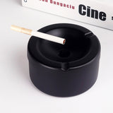 Black stainless steel ashtray with cigarette on top