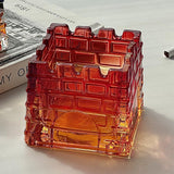 Red gradient geometric glass ashtray on reflective surface
