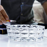 Clear crystal ashtray held in hand, thick heavy glass ashtray with faceted design