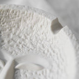 Close-up of textured white ceramic surface on the face expression ashtray