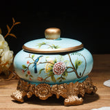 Light blue floral ceramic ashtray with lid and decorative bronze stand