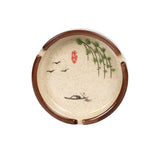 Round Japanese-style ceramic ashtray with cream speckled glaze, botanical pattern, and three cigarette rests