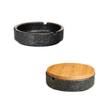 Black round ceramic ashtray with textured glaze and built-in cigarette rests