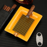 Yellow ceramic cigar ashtray with cigar on black tabletop