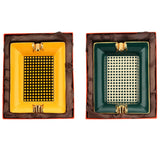 Yellow and teal ceramic cigar ashtrays shown side by side