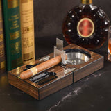 Open walnut cigar travel set with cigars and ashtray beside liquor bottle