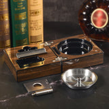 Walnut cigar travel set with ashtray and accessories on tabletop beside liquor bottle