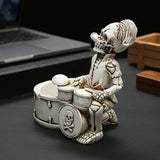 Profile view of skeleton drummer resin ashtray on desk