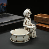 Skull drummer resin ashtray shown on desk from a wider angle